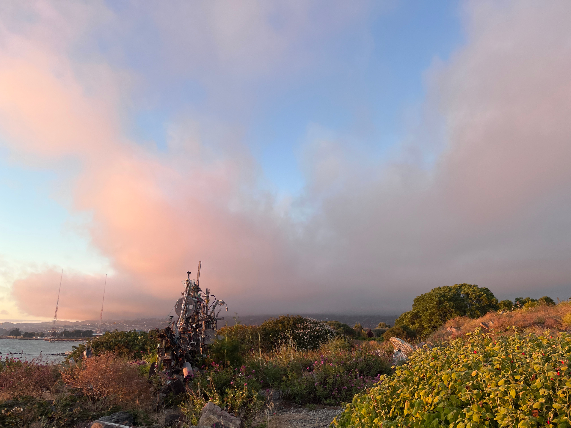 Pink sunset clouds over the Albany Bulb sculpture and bay